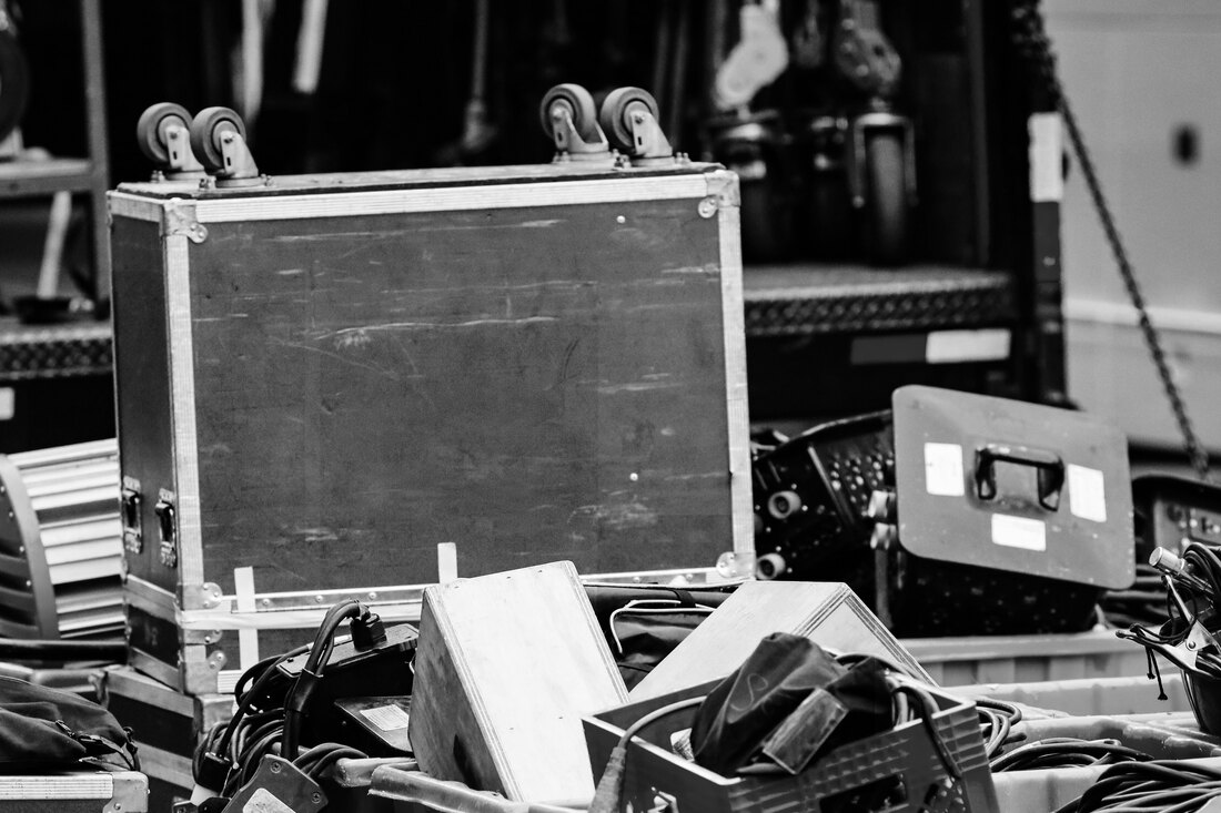 Scuffed flight cases, crates and cables stacked beside an open truck